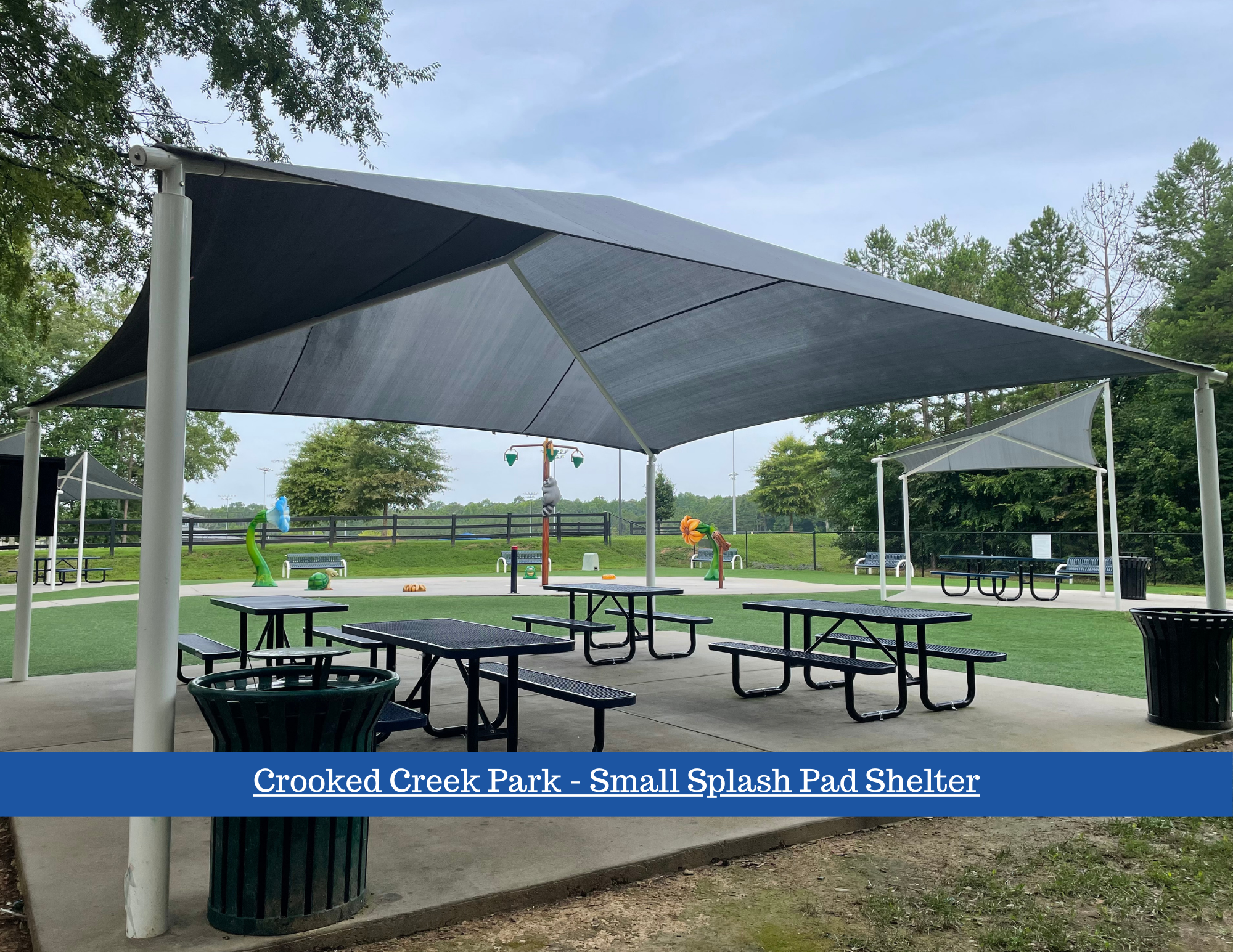 Covered shelter with picnic tables in the Splash Pad. 