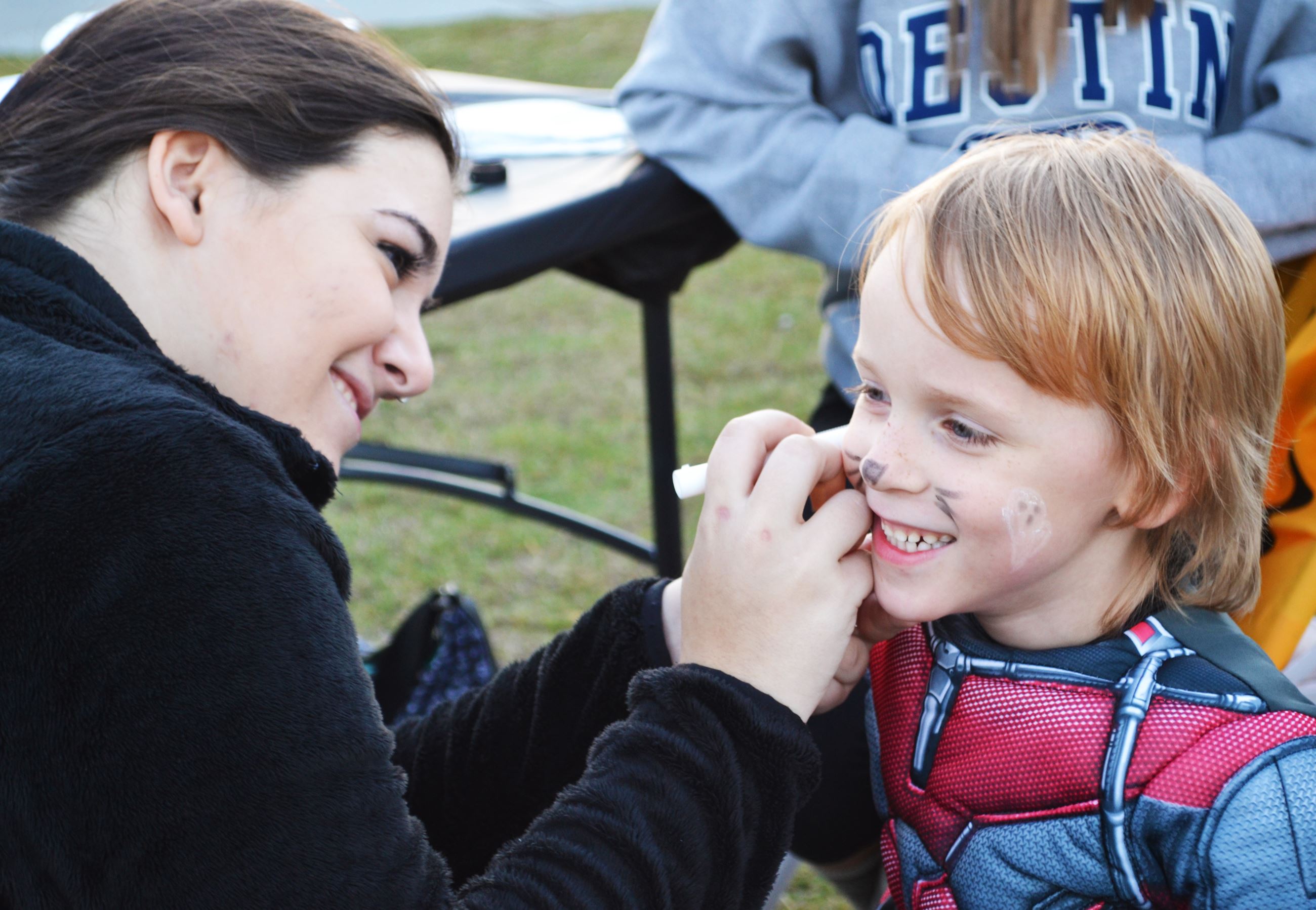 A child has his face painted.