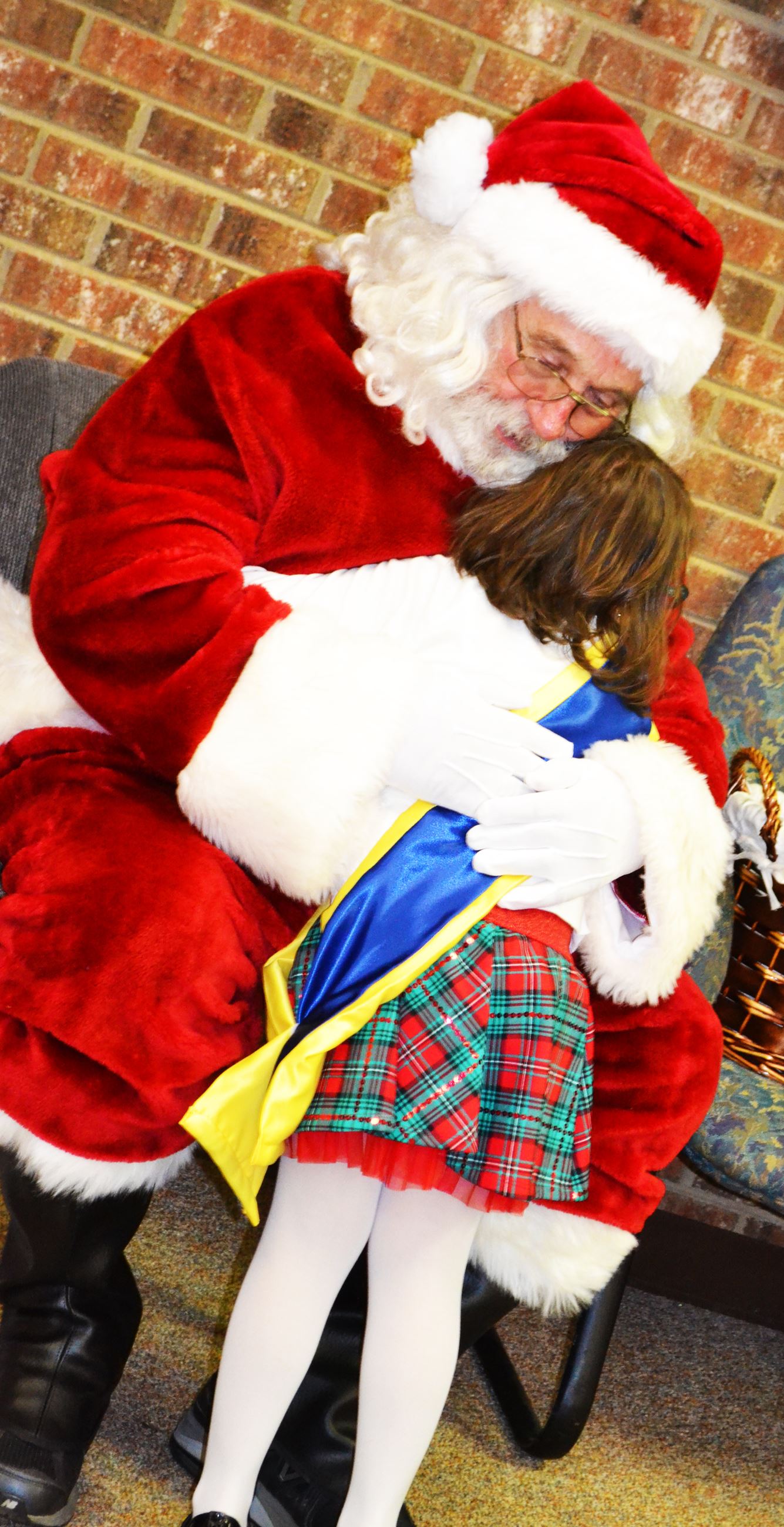 The parade Grand Marshal hugs Santa.